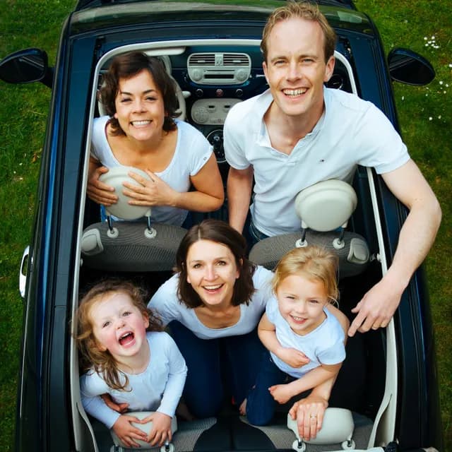 Symbolfoto: Familie mit drei Kindern im Auto